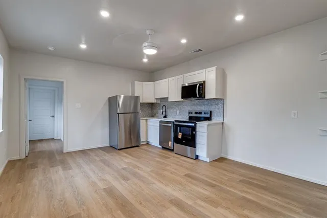 a kitchen with stainless steel appliances a refrigerator and a stove top oven
