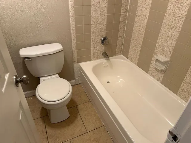 a white toilet sitting next to a bath tub