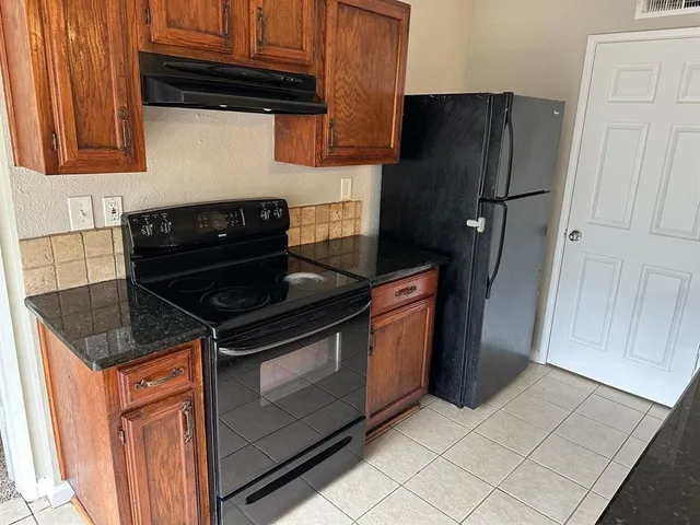 a kitchen with stainless steel appliances granite countertop a refrigerator and a stove