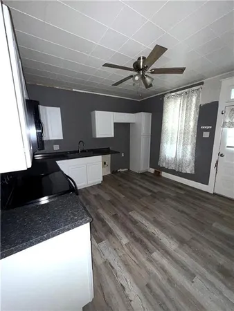 a kitchen with stainless steel appliances kitchen island granite countertop a stove and a wooden floor