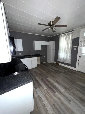 a kitchen with stainless steel appliances kitchen island granite countertop a stove and a wooden floor