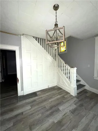 a view of an empty room with wooden floor cabinets and a window
