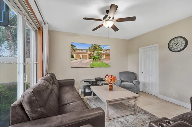 a living room with furniture a clock on wall and a window