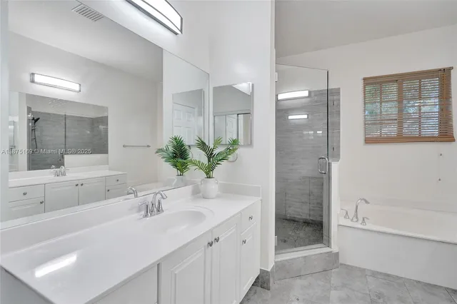 a room with a white tub flowerpot and mirror