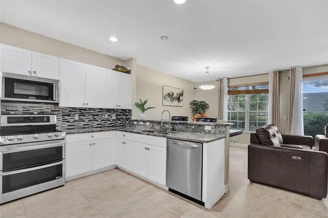 a kitchen with stainless steel appliances granite countertop a stove and a sink