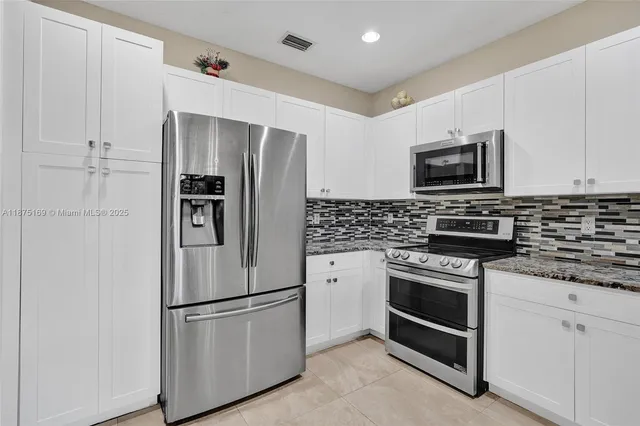 a kitchen with stainless steel appliances a refrigerator stove and microwave