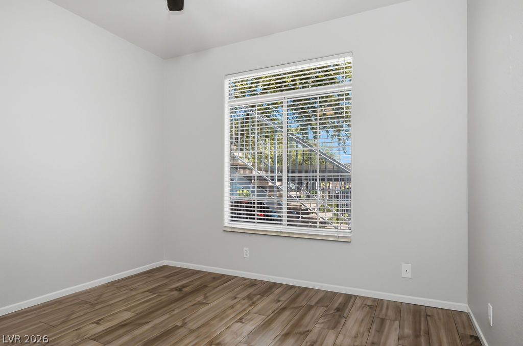 2201 Ramsgate Drive, Unit 514 Henderson, NV 89074 - Photo 17 of 28 Wood plank flooring extends across a neutral-toned room with a large window.