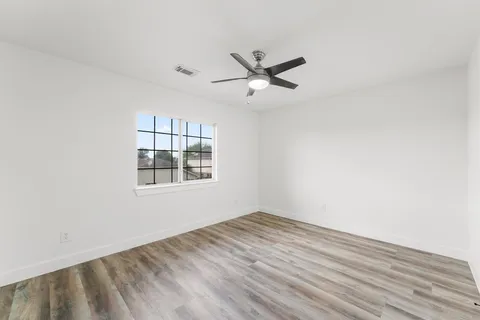 a view of a big room with wooden floor and windows