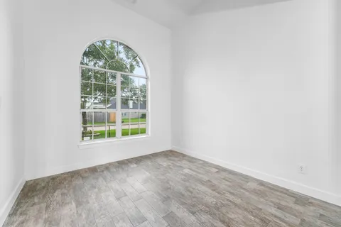 an empty room with wooden floor and a window
