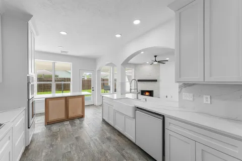 a large kitchen with a lot of counter space and a wooden floor