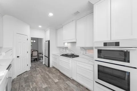 a kitchen with white cabinets and appliances