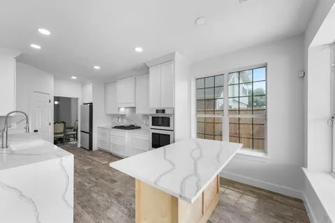 a kitchen with refrigerator cabinets and large window
