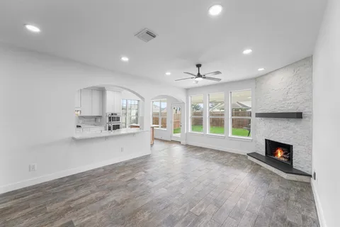 a view of an empty room with a fireplace and a large window
