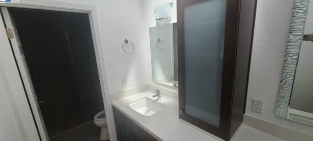 a bathroom with a sink and mirror with toilet