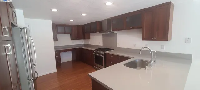 a kitchen with stainless steel appliances granite countertop a sink stove and refrigerator