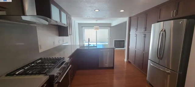 a kitchen with stainless steel appliances granite countertop a refrigerator and a stove