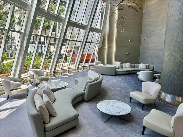a living room with furniture and floor to ceiling windows