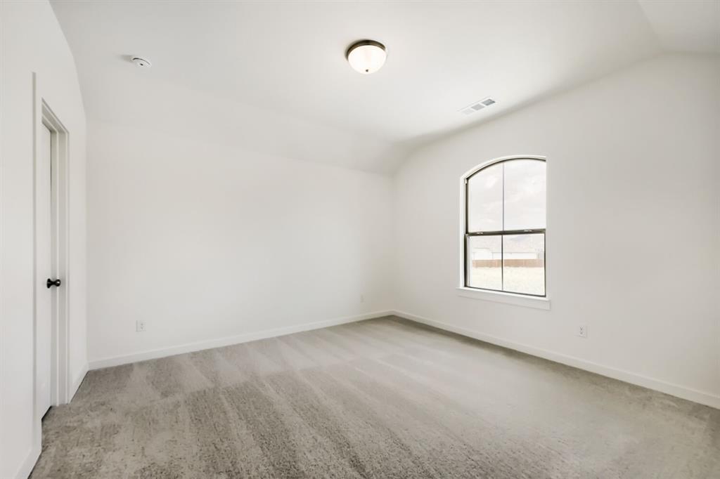 11465 Wulstone Road Fort Worth, TX 76052 - Photo 17 of 27 Neutral white wall paint, vaulted ceiling, and gray carpeted flooring