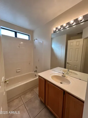 a bathroom with a sink a tub and a mirror