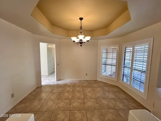 a view of a livingroom with a chandelier fan and windows