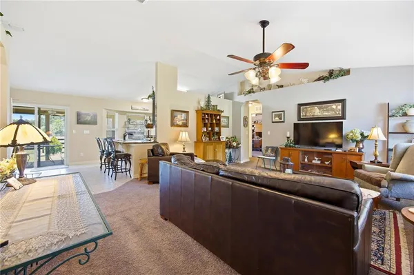 a living room with furniture a flat screen tv and kitchen view