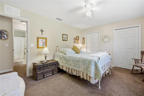 a spacious bedroom with a bed and a chandelier