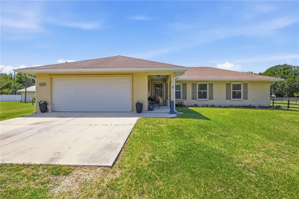 a front view of house with yard and outdoor seating