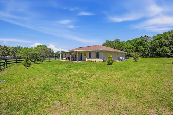 a house view with swimming pool in front of it