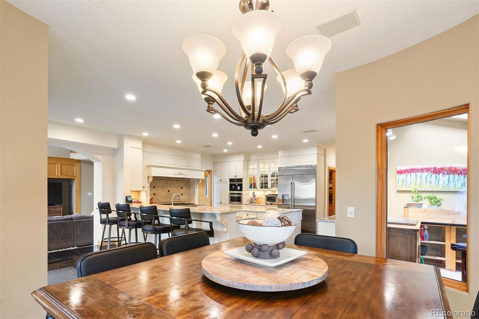 29115 Summit Ranch Drive Golden, CO 80401 - Photo 15 of 50 a living room with dining table a large window and stainless steel appliances