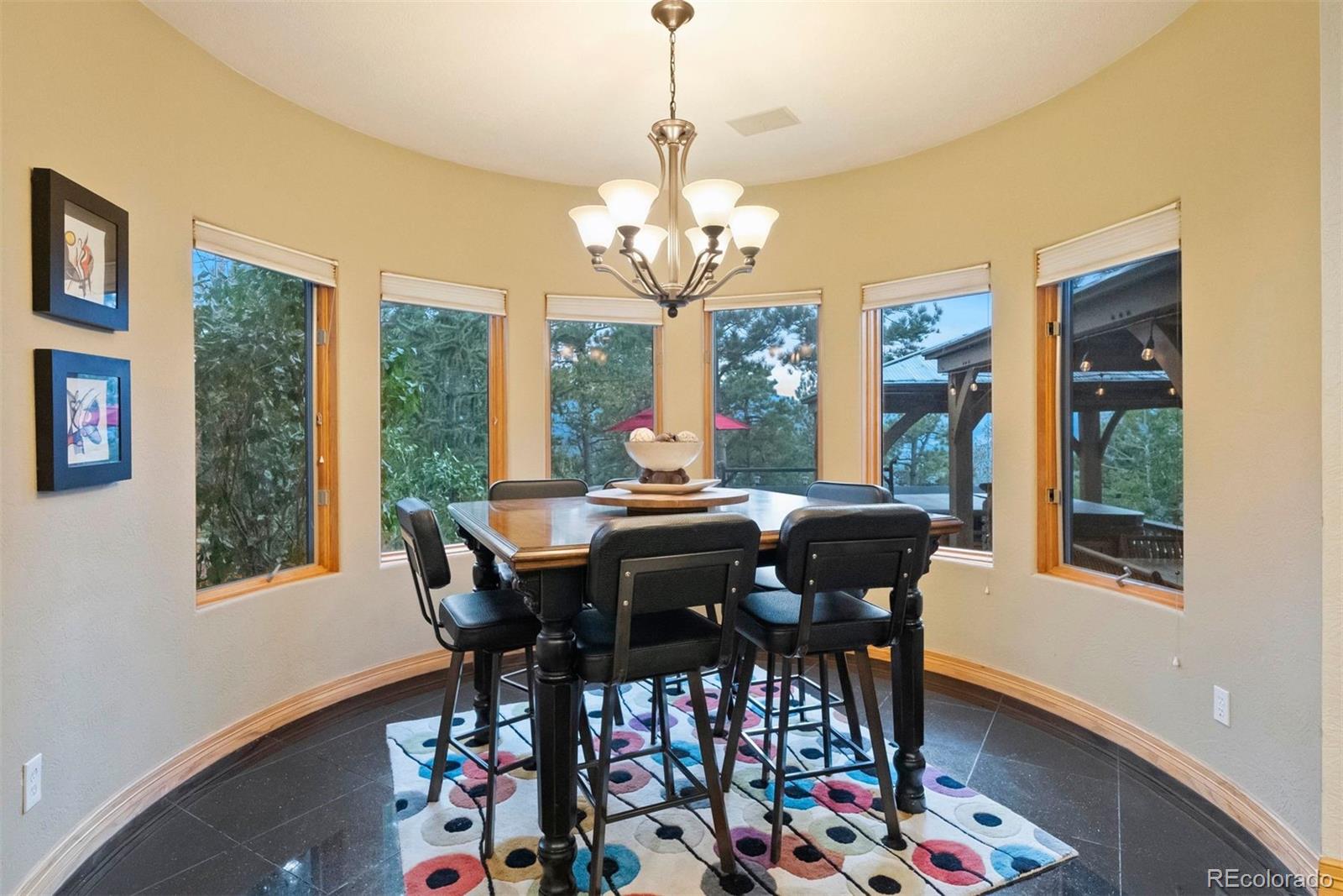 29115 Summit Ranch Drive Golden, CO 80401 - Photo 23 of 50 a view of a dining room with furniture a chandelier and wooden floor