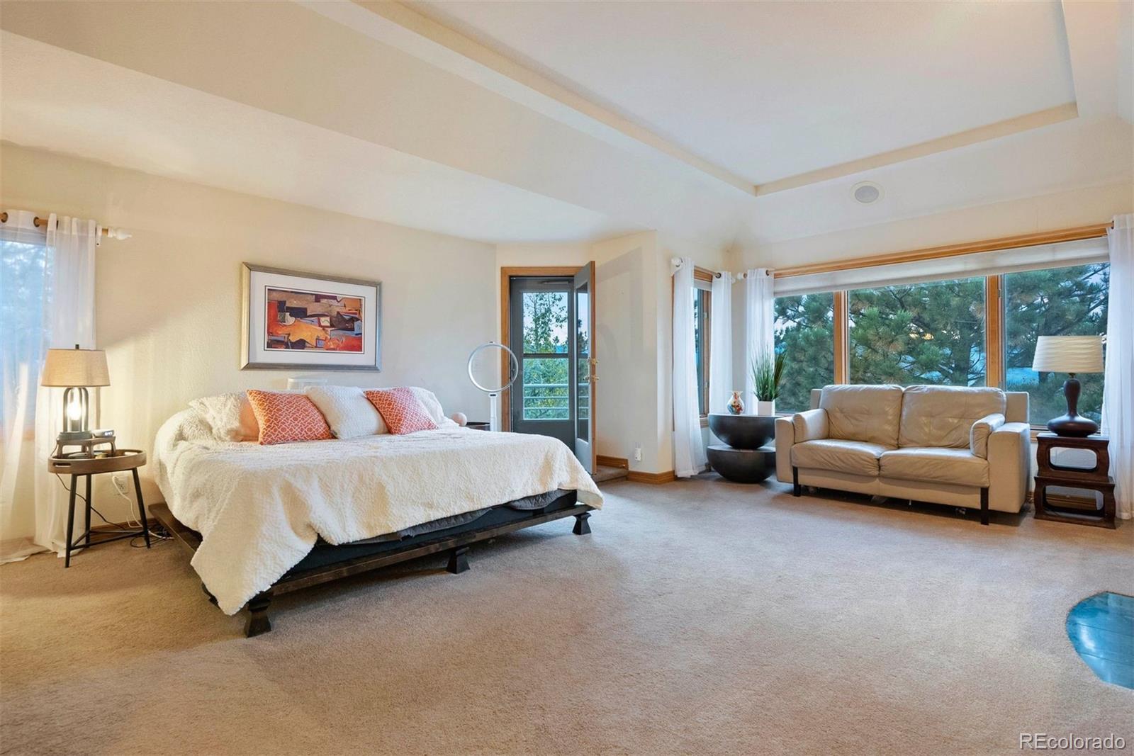29115 Summit Ranch Drive Golden, CO 80401 - Photo 25 of 50 a spacious bedroom with a bed couch and a large window
