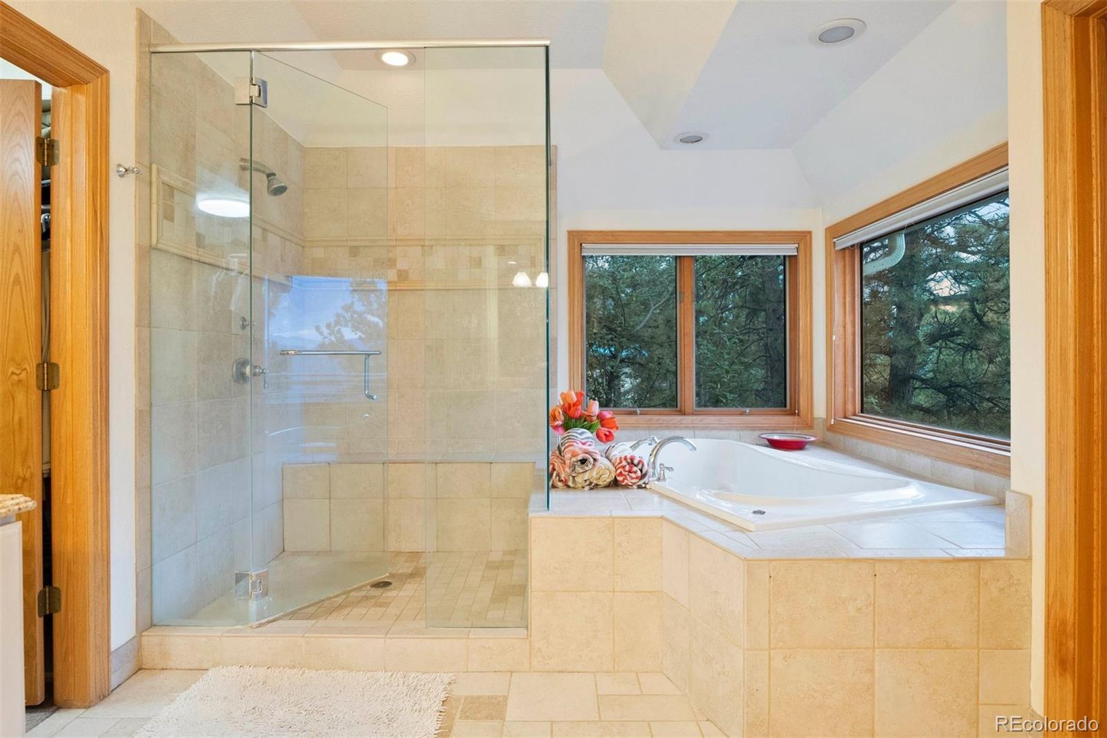 29115 Summit Ranch Drive Golden, CO 80401 - Photo 27 of 50 a bathroom with a tub shower and window