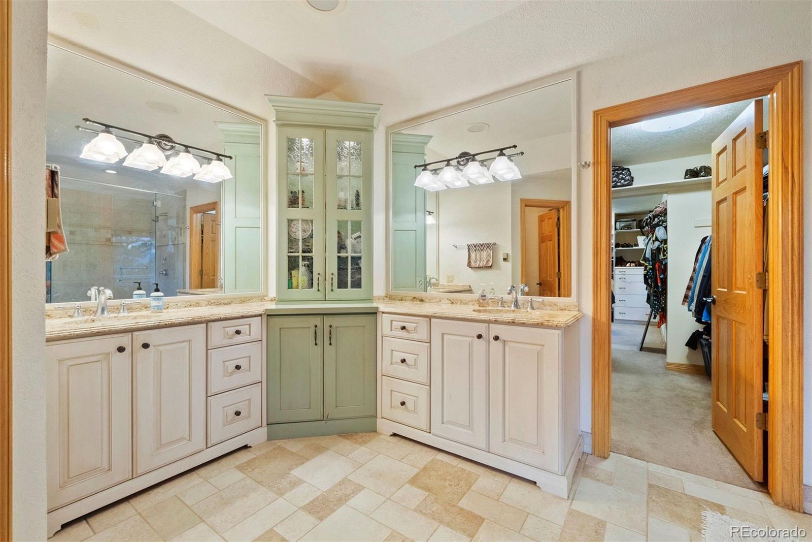 29115 Summit Ranch Drive Golden, CO 80401 - Photo 28 of 50 a spacious bathroom with a granite countertop sink mirror and a