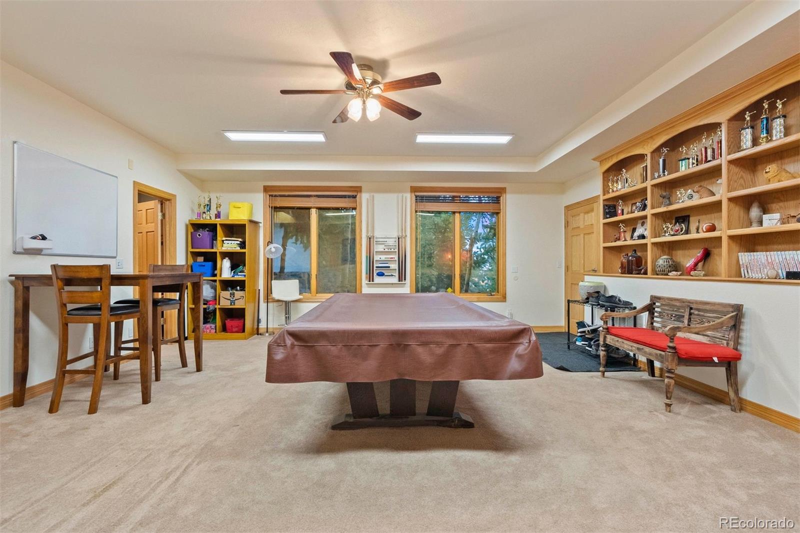 29115 Summit Ranch Drive Golden, CO 80401 - Photo 48 of 50 a living room with furniture a ceiling fan and a book shelf