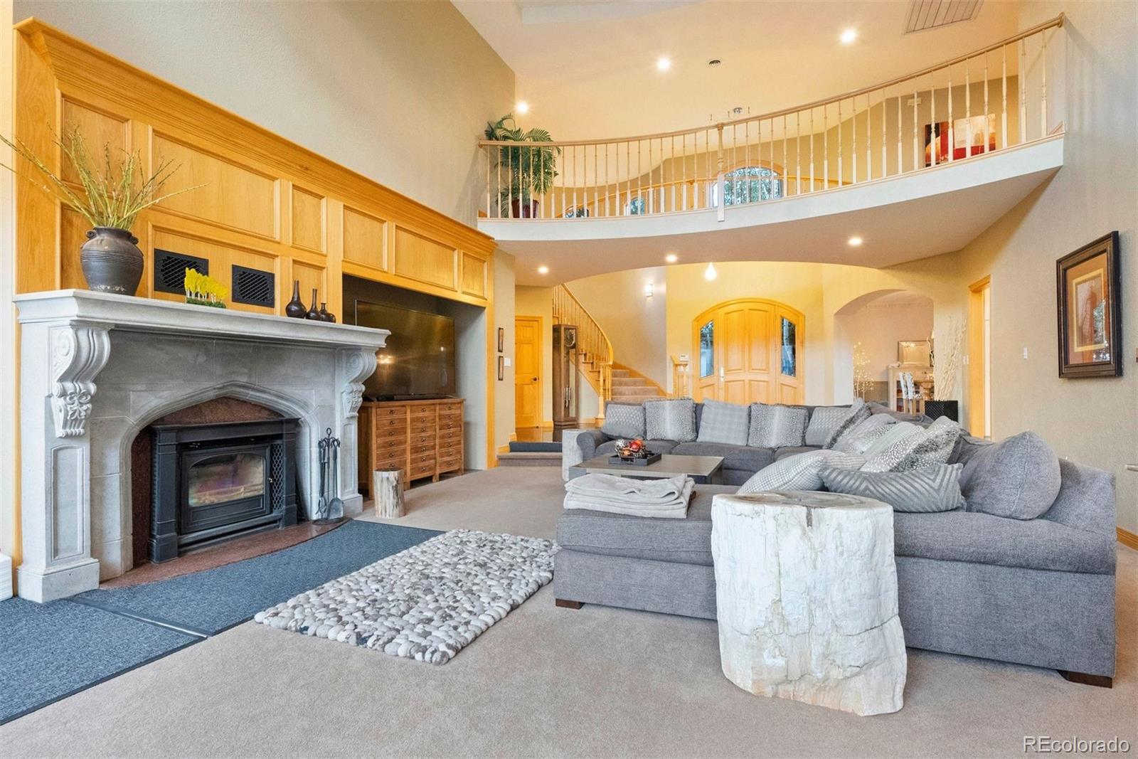 29115 Summit Ranch Drive Golden, CO 80401 - Photo 6 of 50 a living room with furniture a fireplace and a kitchen view