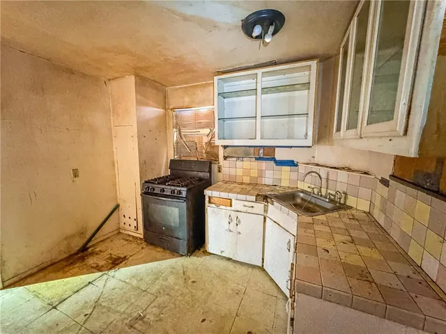 a white kitchen with a stove top oven