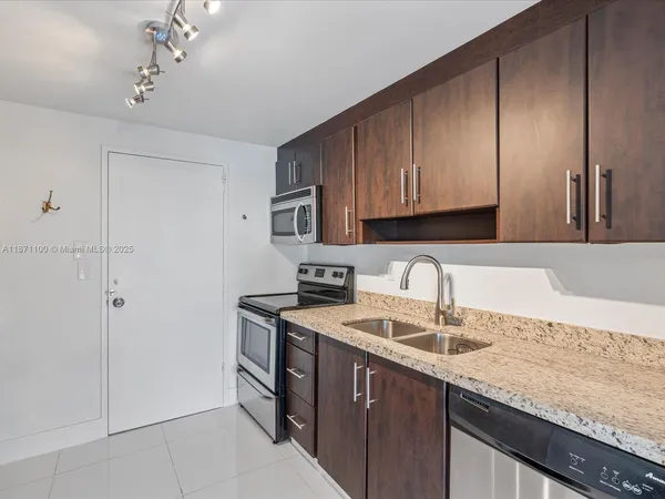 a kitchen with a sink cabinets and appliances