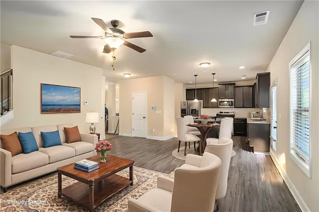 a living room with furniture kitchen view and a chandelier