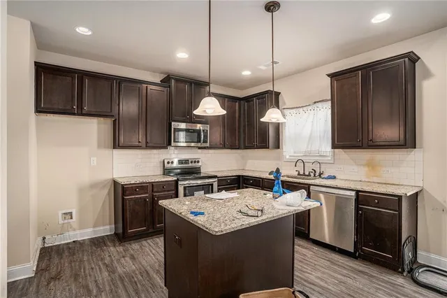 a kitchen with a sink a stove a refrigerator and cabinets