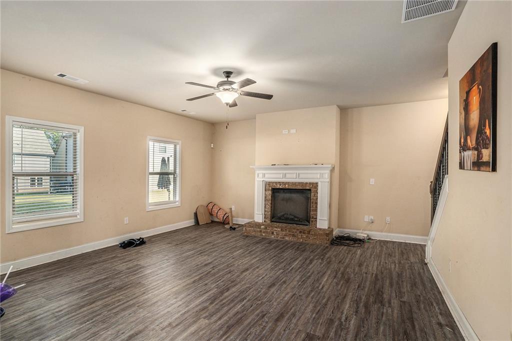 2277 Church Street Hampton, GA 30228 - Photo 6 of 30 an empty room with windows fireplace and wooden floor