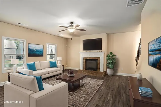 a living room with furniture a fireplace and a flat screen tv