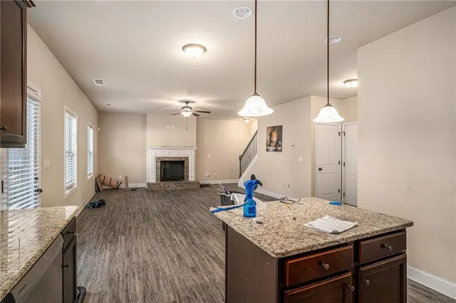 a kitchen with a sink a chandelier and wooden floor
