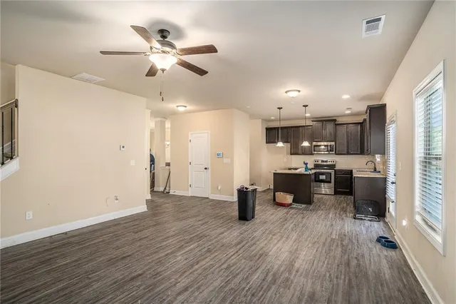 a view of a kitchen with cabinets stainless steel appliances and a ceiling fan