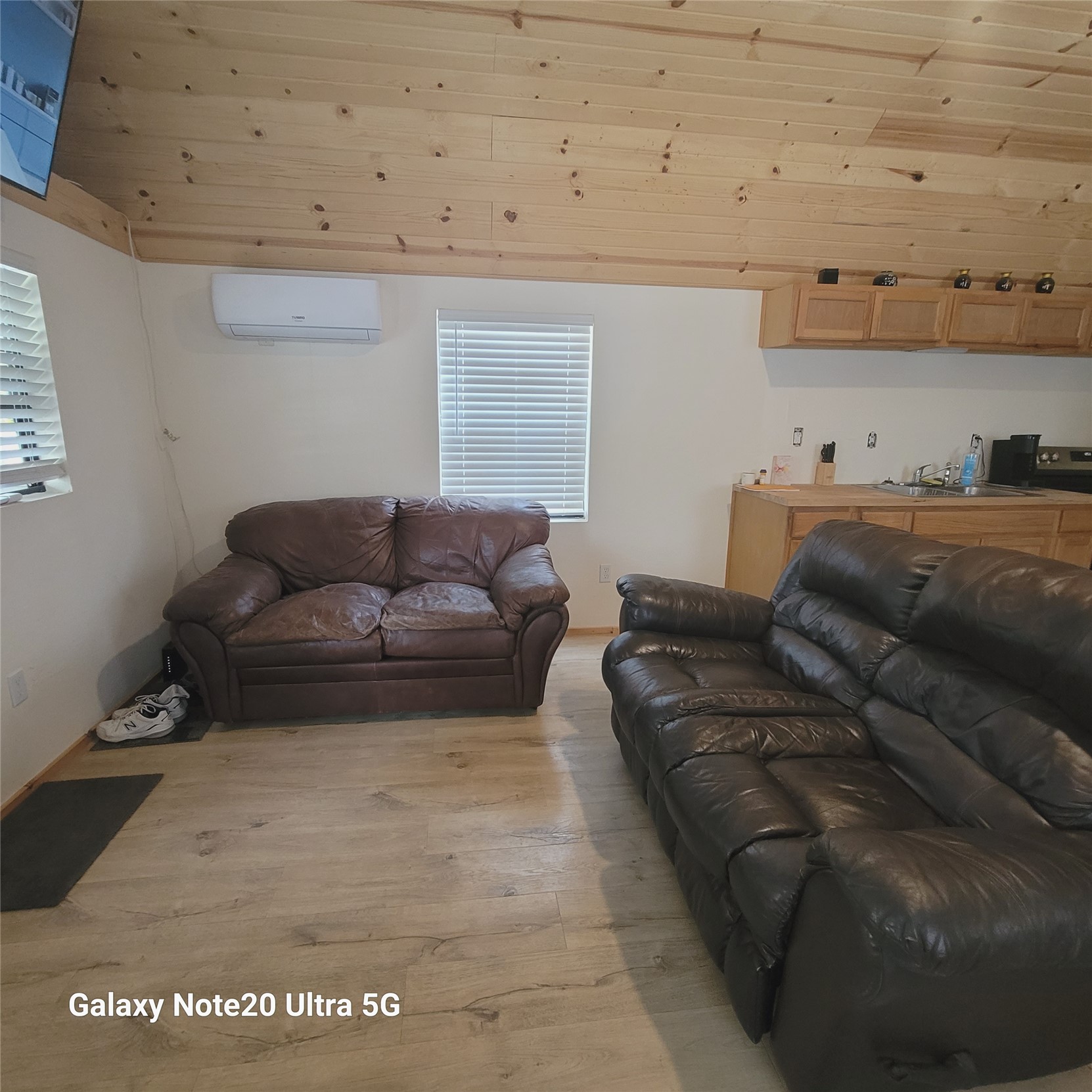 115 Locust Road Stigler, OK 74462 - Photo 14 of 29 Wood-finish flooring, wood plank ceiling, window with blinds, wall-mounted air conditioning unit, and built-in cabinetry