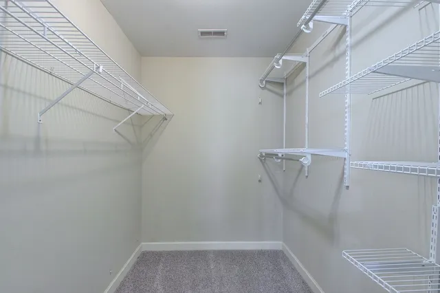 a view of walk in closet with empty racks