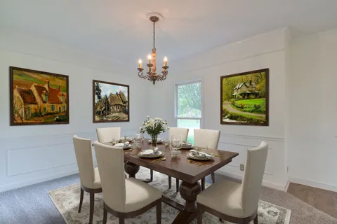 a view of a dining room with furniture a chandelier and wooden floor