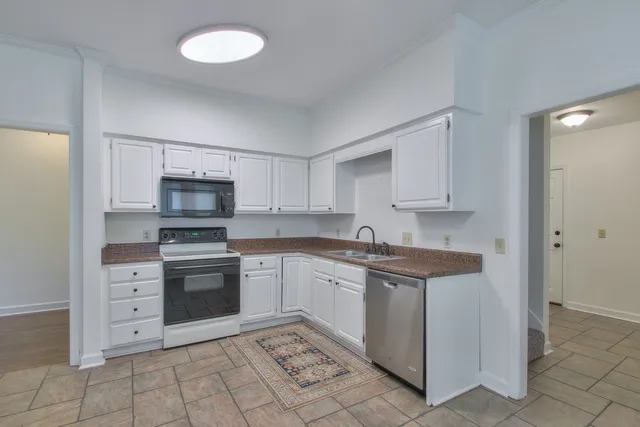 a kitchen with stainless steel appliances granite countertop a stove and white cabinets