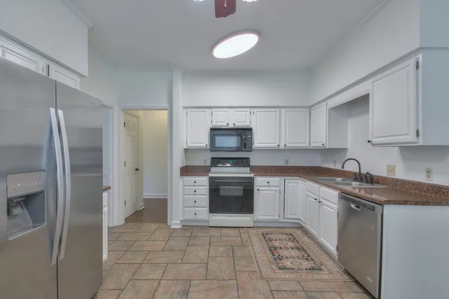 a kitchen with stainless steel appliances granite countertop a refrigerator and a sink