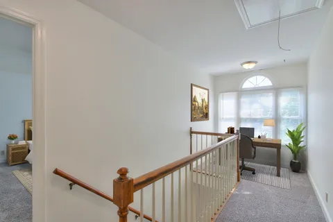 a view of a hallway with workspace and windows