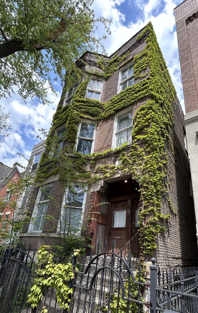 a tall building with lots of plant in front of it
